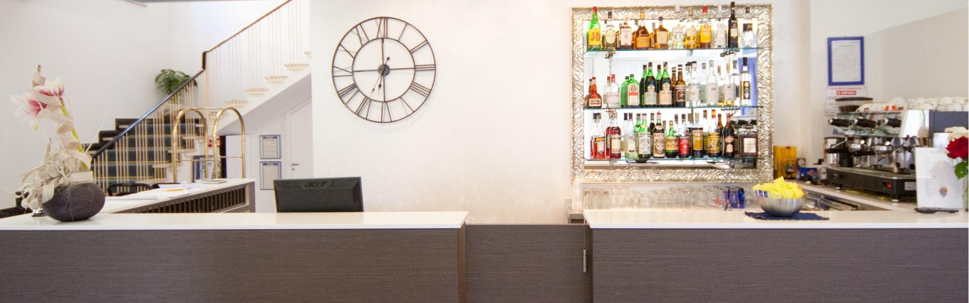 Reception con orologio e bar ben fornito.