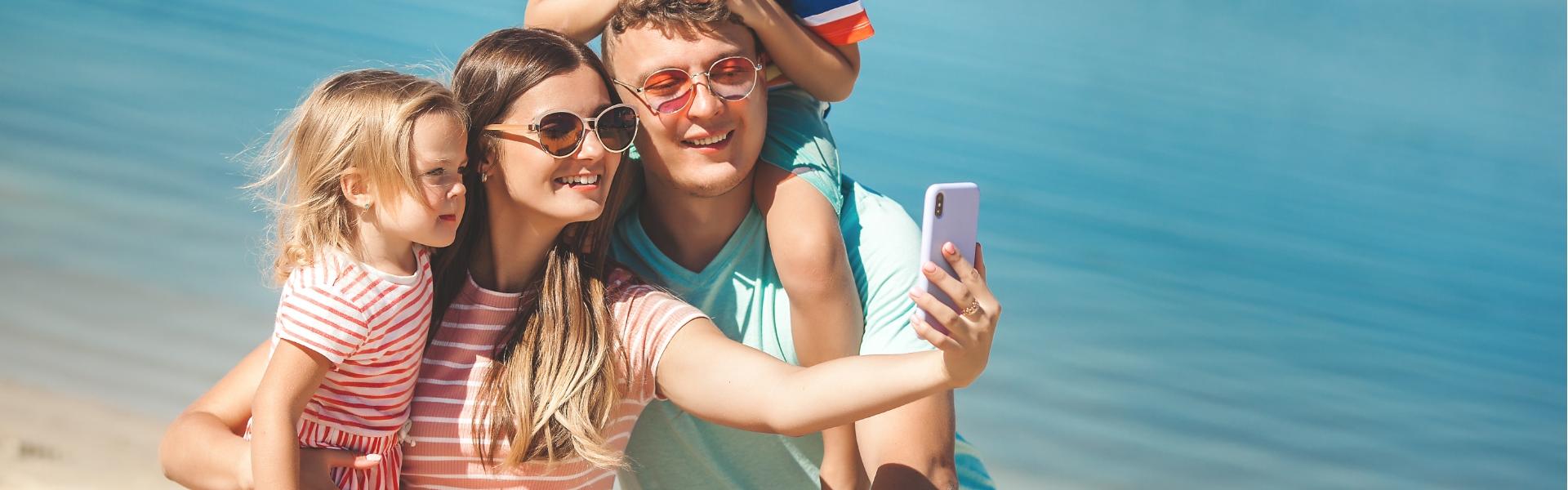 Happy family taking a selfie at the beach.