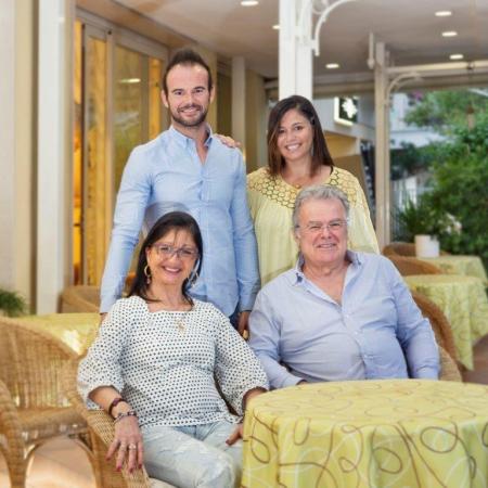 Lächelnde Familie sitzt draußen in einem Restaurant.