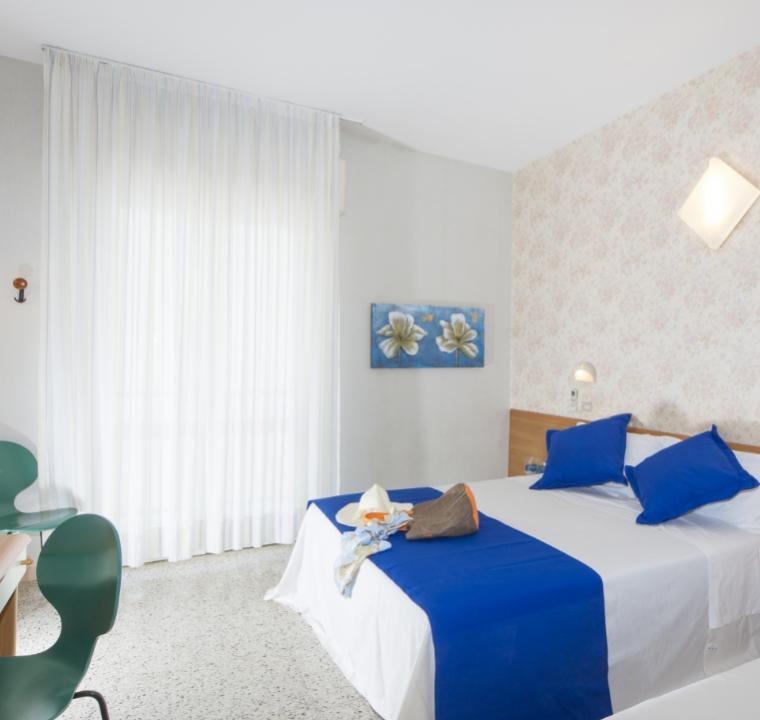 Camera luminosa con letto matrimoniale e decorazioni blu.